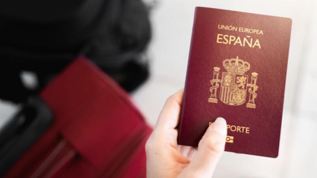 persona con su pasaporte en mano junto a maleta de fondo