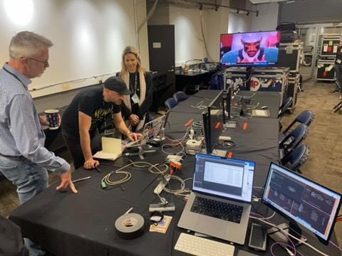 Equipo de tres fotógrafos revisan varias imágenes en computadoras.