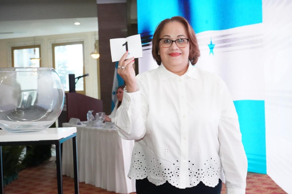 esposa de Jorge Zelaya sosteniendo el número 1 en un papel