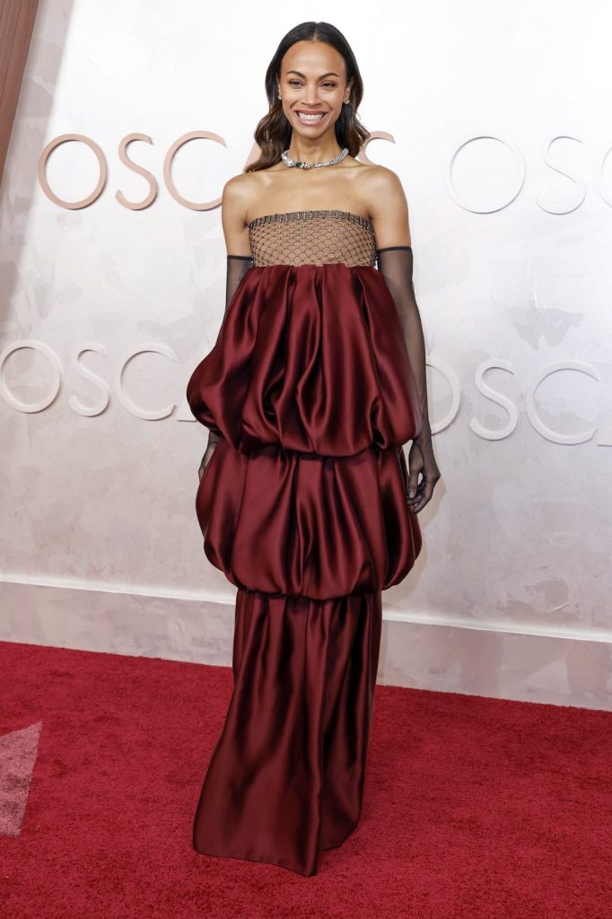 Zoe Zaldaña con vestido rojo y guantes transparentes