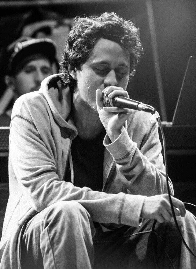 Canserbero sosteniendo un micrófono