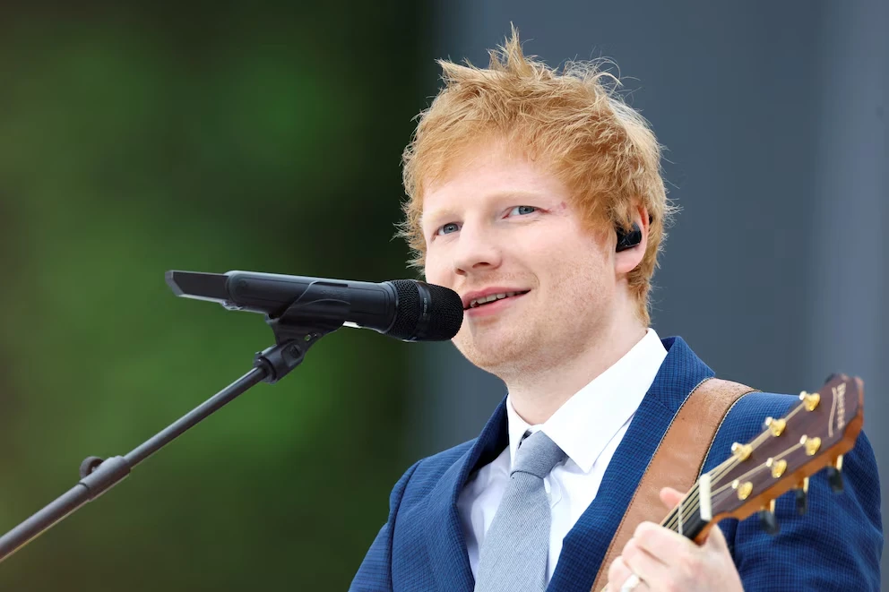 Ed Sheeran vestido con un traje azul mientras canta. Foto: cortesía de Infobae 