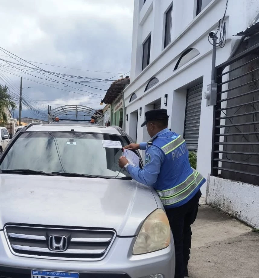 policia dejando multa en carro