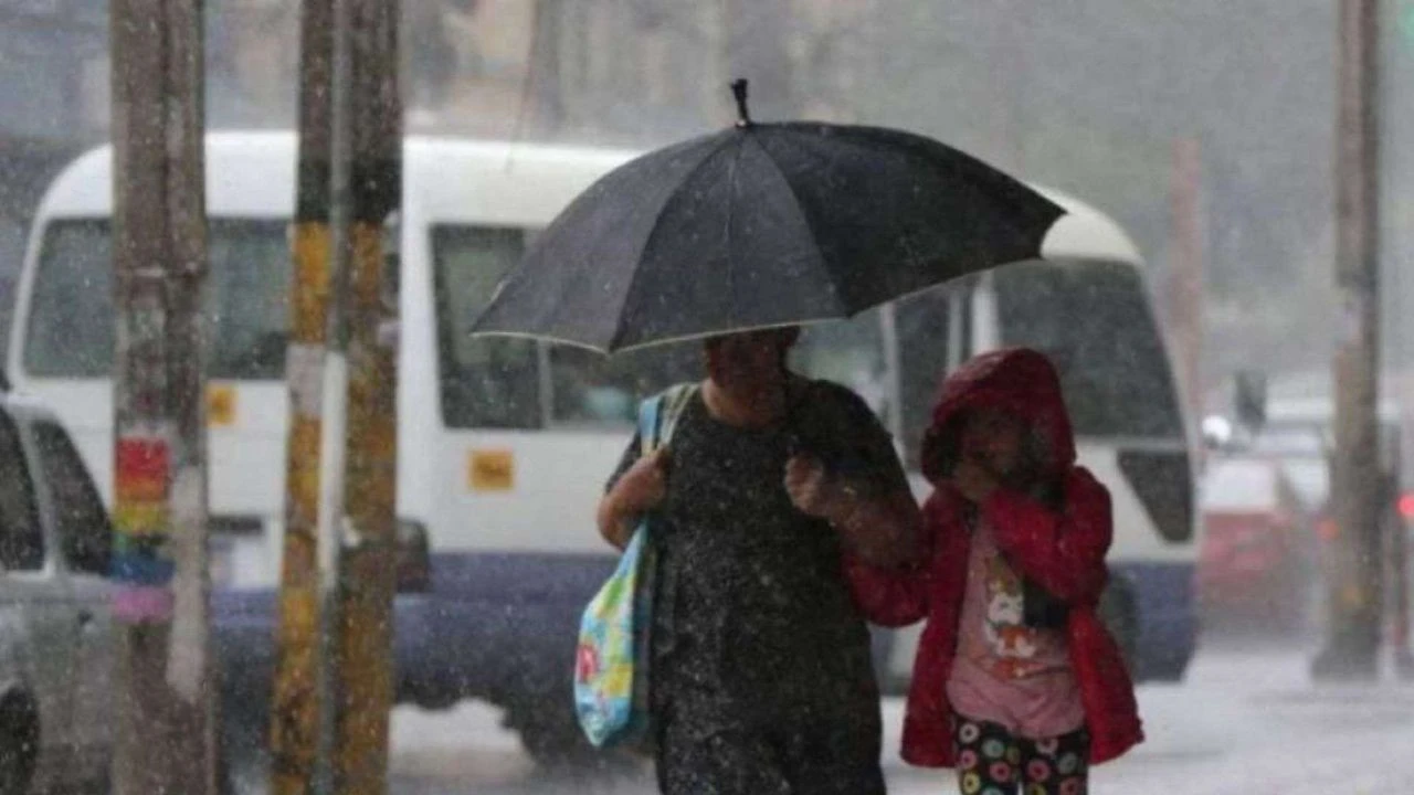 Mujer con una niña caminando con una sombrilla