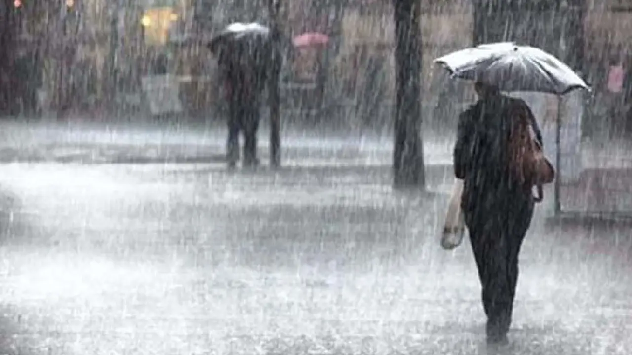 Imagen de referencia de una mujer caminando bajo la lluvia.