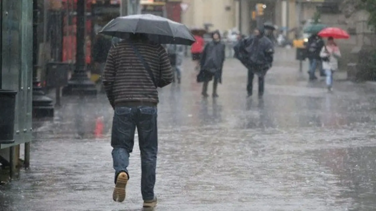 Imagen que muestra a una persona caminando bajo la lluvia.